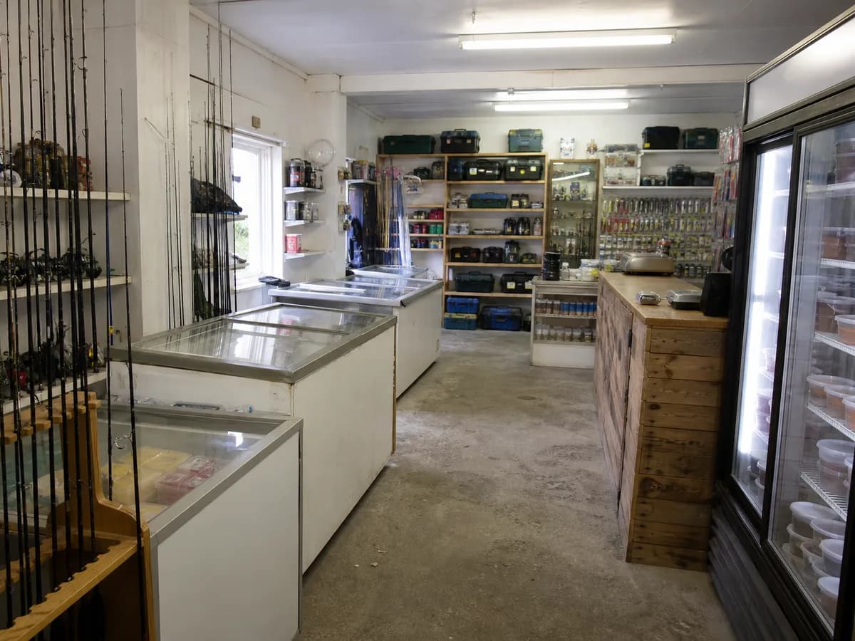 Inside the shop: rod racks, bait fridges and the counter.